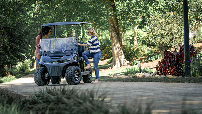 Two people getting into an E-Z-GO vehicle