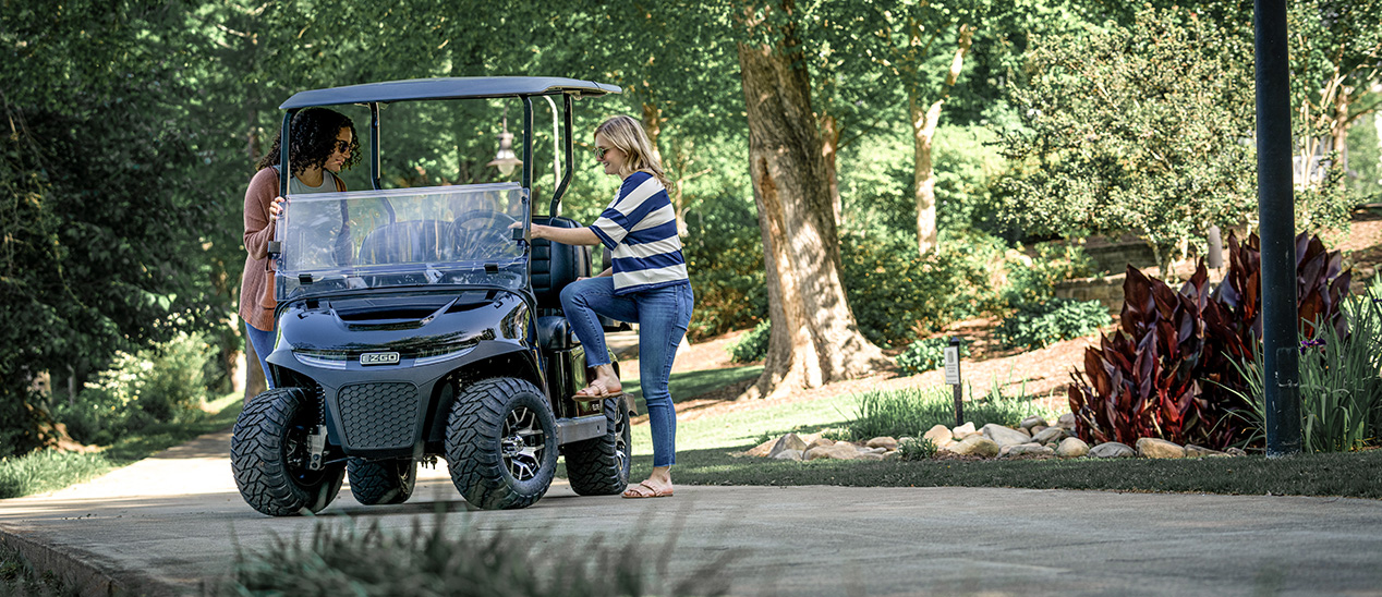 Two women board an E-Z-GO Freedom RXV vehicle.