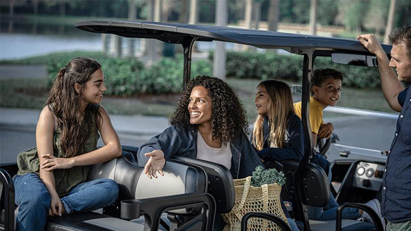 Four people in an E-Z-GO vehicle. 