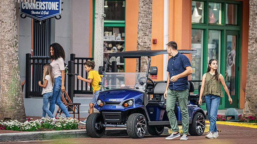 E-Z-GO vehicle parked on a street, and passengers exiting.