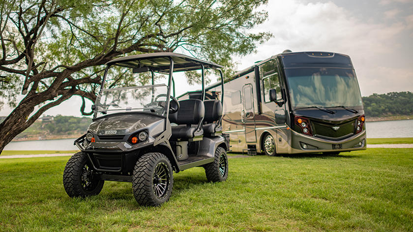 An E-Z-GO Liberty model sitting alongside a large RV.